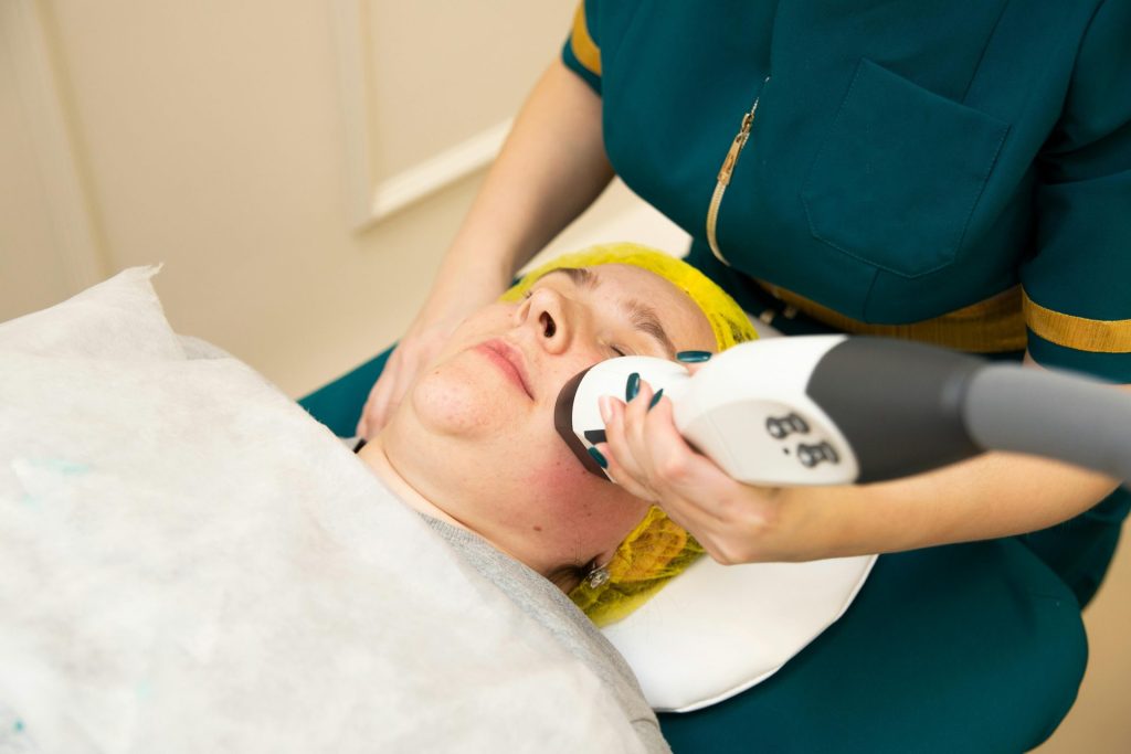 Gros plan sur une femme recevant un soin du visage moderne dans un institut de beauté.